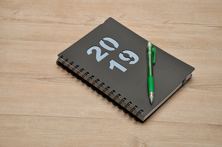 A diary for 2019 and a pencil on a wooden backgroundの写真素材