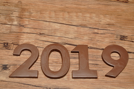 2019 in chocolate figures against a wooden backgroundの写真素材