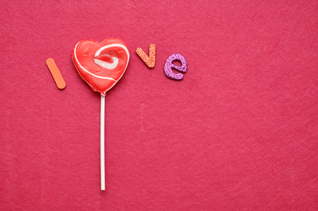 A heart shape lollipop forming a part of the word loveの写真素材