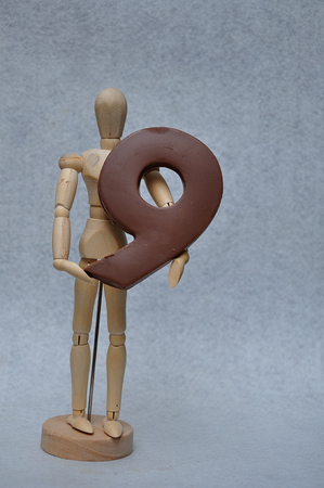 A wooden art mannequin with a chocolate number nineの写真素材