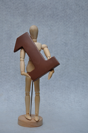 A wooden art mannequin with a chocolate number oneの写真素材