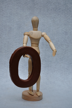 A wooden art mannequin with a chocolate number zeroの写真素材
