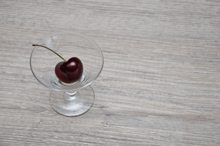 A single cherry in a glass bowlの写真素材