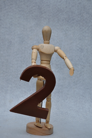 A wooden art mannequin with a chocolate number twoの写真素材