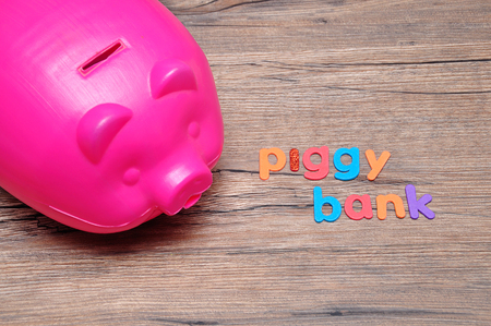 A plastic piggy bank on a table with the words piggy bankの写真素材