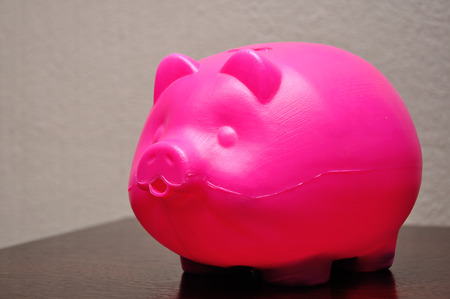 A plastic piggy bank on a tableの写真素材