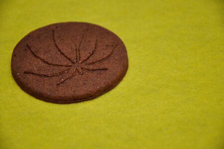 A golden brown cannabis biscuit with a cannabis leave printの写真素材