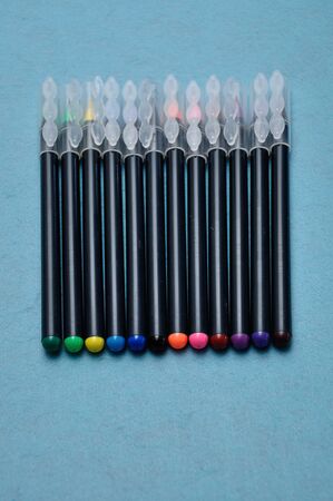 An assortment of color pens on a blue backgroundの写真素材
