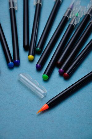 An orange color pen with the rest out of focus on a blue backgroundの写真素材