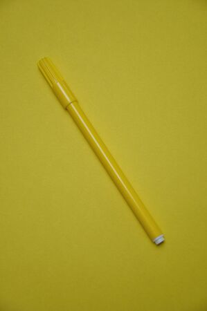 A yellow pen isolated on a yellow backgroundの写真素材