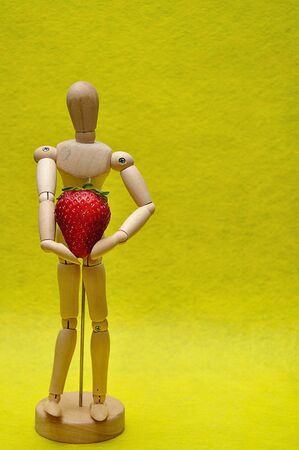 A wooden mannequin with a strawberryの写真素材