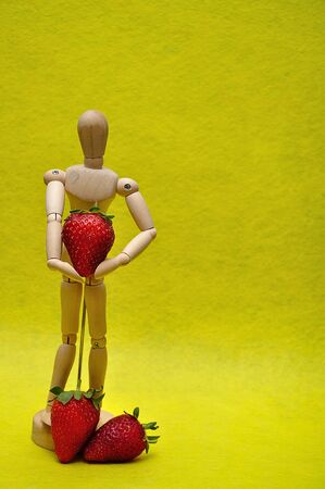 A wooden mannequin with strawberriesの写真素材