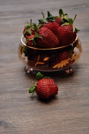 A bowl of strawberries on a wooden backgroundの写真素材