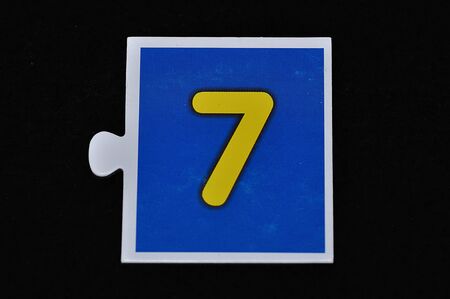 A jigsaw piece with the figure seven