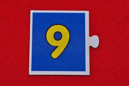 A jigsaw piece with the figure nineの写真素材