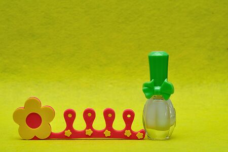 A bottle of white nail polish with a toe separatorの写真素材