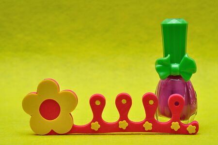 A bottle of pink nail polish with a toe separatorの写真素材
