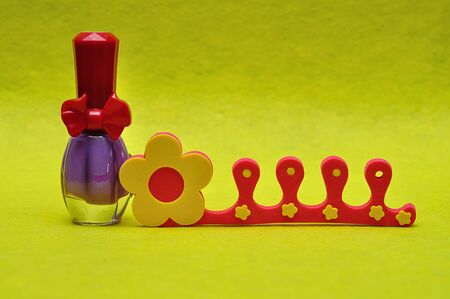 A bottle of purple nail polish with a toe separatorの写真素材