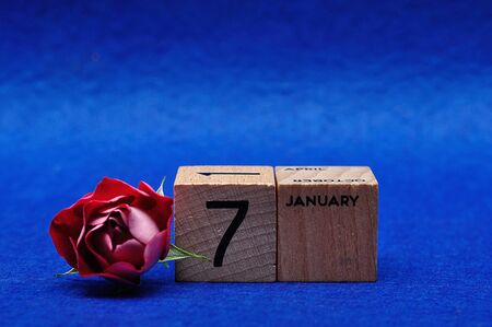 7 January on wooden blocks with a red rose on a blue backgroundの写真素材