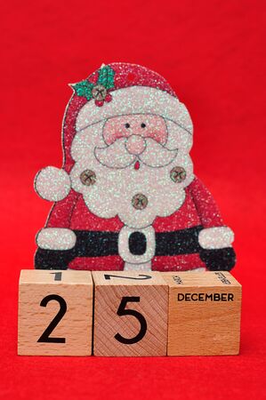 25 December on wooden blocks with a christmas father on a red backgroundの写真素材