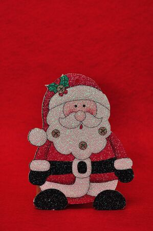 A christmas father figurine against a red backgroundの写真素材