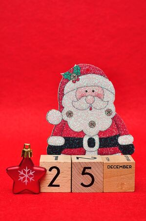 25 December on wooden blocks with a red star and a christmas father on a red backgroundの写真素材
