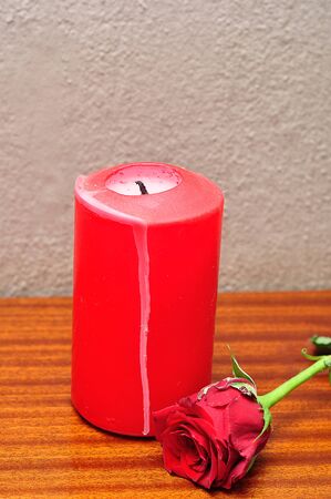 A red candle with a red roseの写真素材