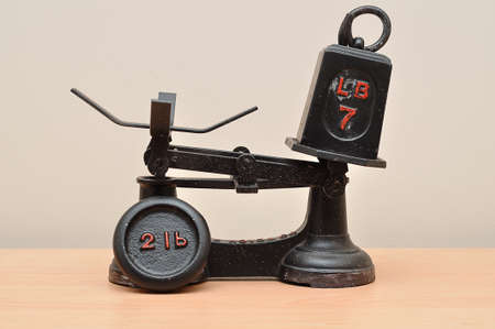 A vintage food scale with a seven and two pound weightsの写真素材