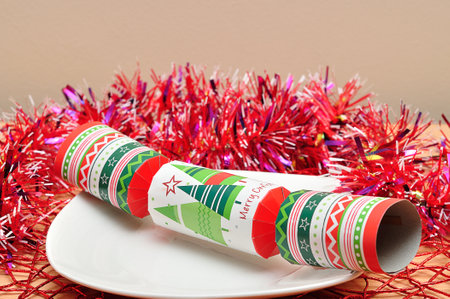 Christmas table decorated with a plate, tinsel and a christmas crackerの写真素材