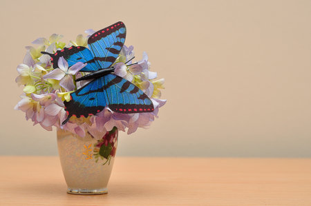 Hydrangeas in a pot decorated with an artificial butterflyの写真素材