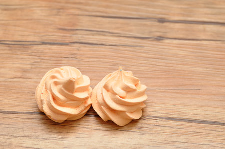 Two orange meringues on a tableの写真素材