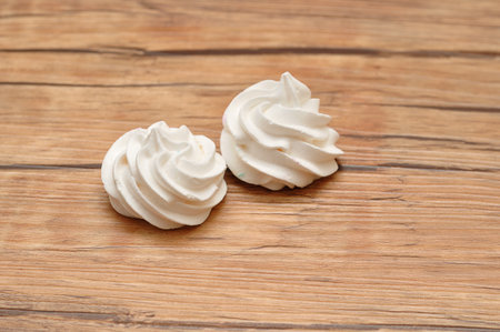 Two white meringues on a tableの写真素材