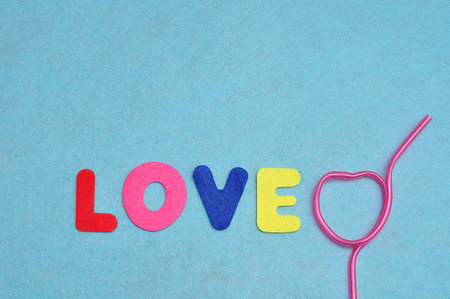 The word love with a heart shape pink strawの写真素材