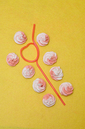 Pink and white meringues displayed with a pink heart shape strawの写真素材