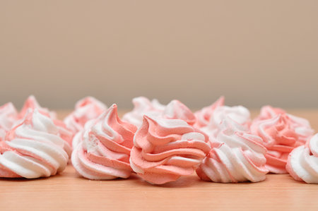 Pink and white meringues on a wooden tableの写真素材