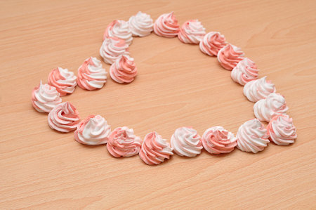 White and pink meringues packed in a shape of a heartの写真素材