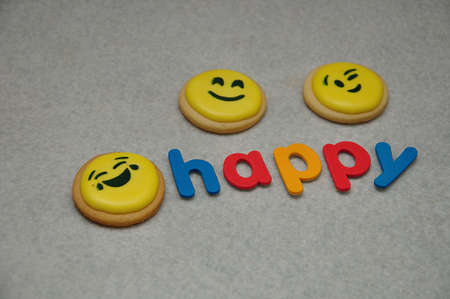 Smiley emojies biscuit with the word happy on a white backgroundの写真素材