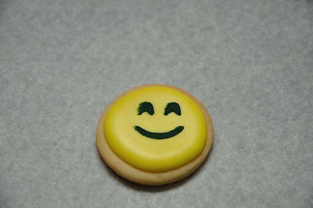A smiley emoji biscuit on a white backgroundの写真素材