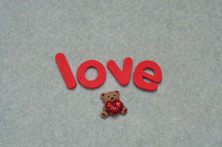 The word love with a small little bear on a white backgroundの写真素材
