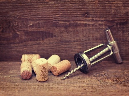 Wine corks with corkscrew on wooden tableの写真素材
