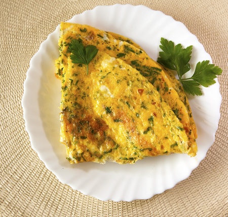 Scrambled eggs with herbs. Omelet on white plate