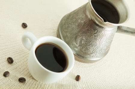 Cup of coffee with beans and arabic coffee potの写真素材