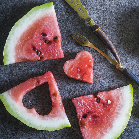Watermelon slices with heart shape on the tableの写真素材