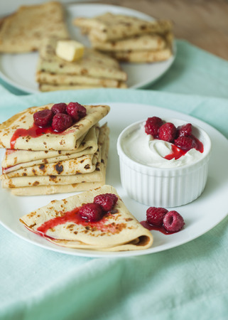 Stack of homemade pancakes with raspberry and sour creamの写真素材