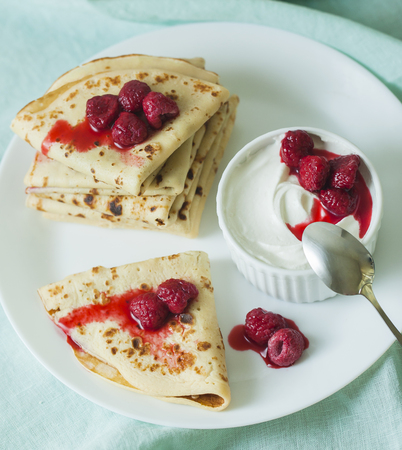 Stack of homemade pancakes with raspberry and sour creamの写真素材