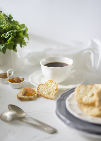 Cup of tea with biscuits and apricot jam on the white tableの写真素材