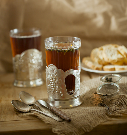 Glass of tea on wooden table in Soviet style glass holderの写真素材