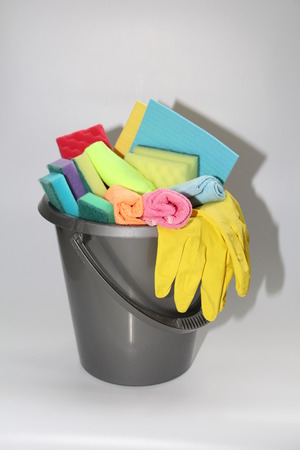 Bucket with tools for cleaning an apartment or office. No one in the photo. In the bucket are latex gloves, sponges for cleaning, detergent, floor cloth.の写真素材