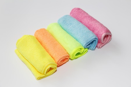 Set of multi-colored microfiber rags for cleaning. Five colored towels on a white background....
