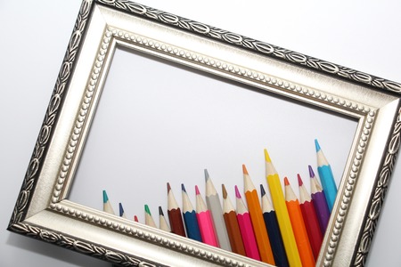 Vintage frame for paintings and colored pencils on a white background. Many colored pencils.の写真素材
